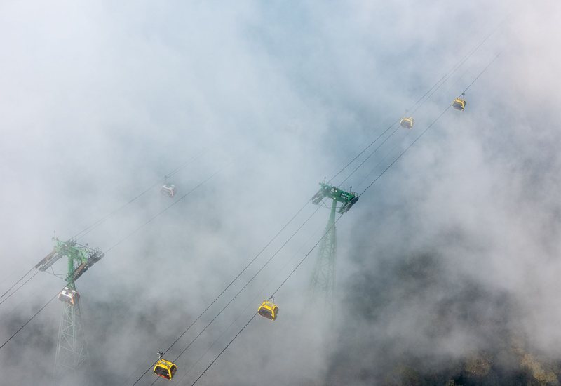 Gondola cabins climbing through low cloud